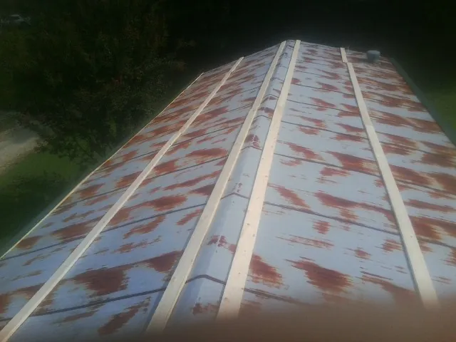 Rusted metal roof panels with new wood purlins before replacement — Storm Damage Roof Repair in Holliston by Roofing Brothers