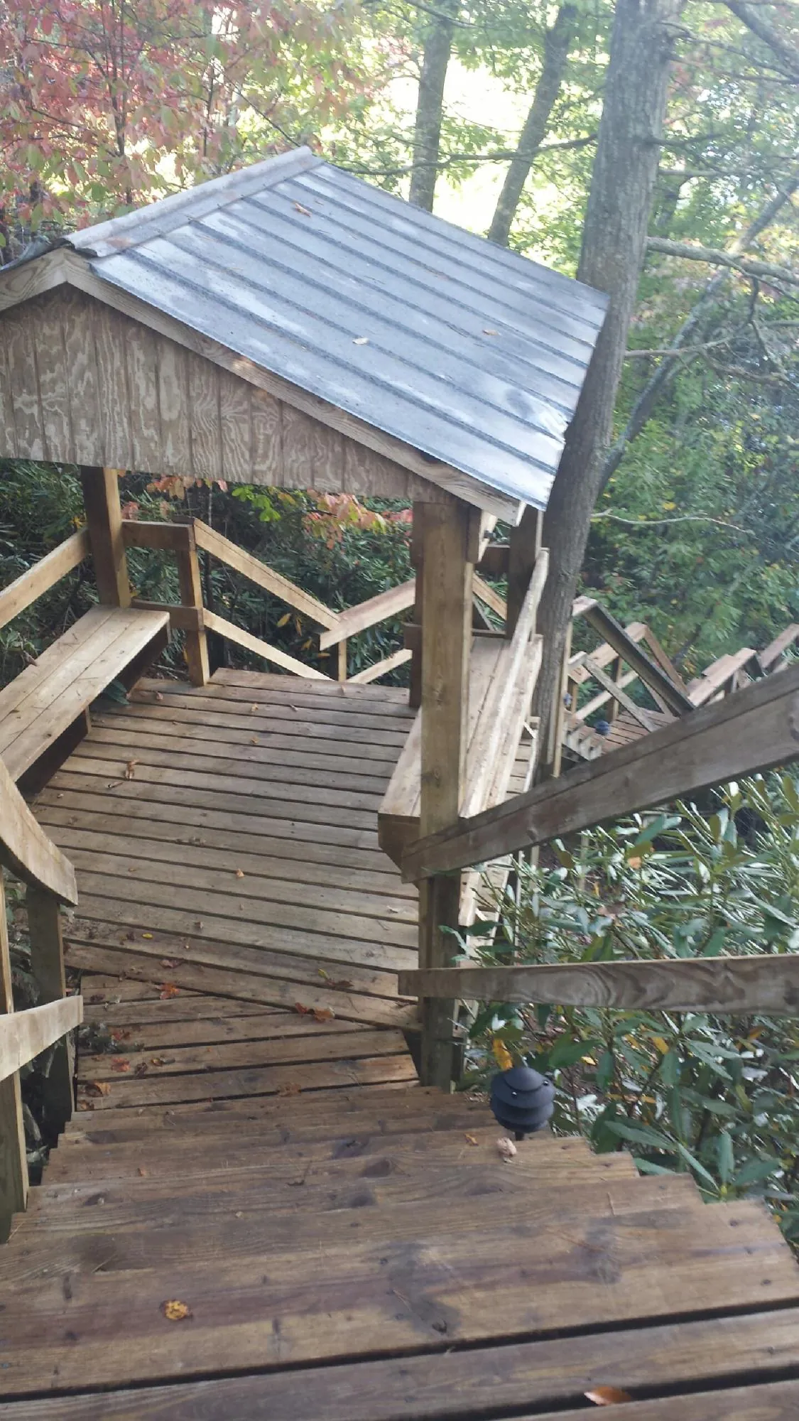 Metal roofed shelter over wooden steps on a wooded walkway — Skylight Repair & Installation work by our crew in Holliston