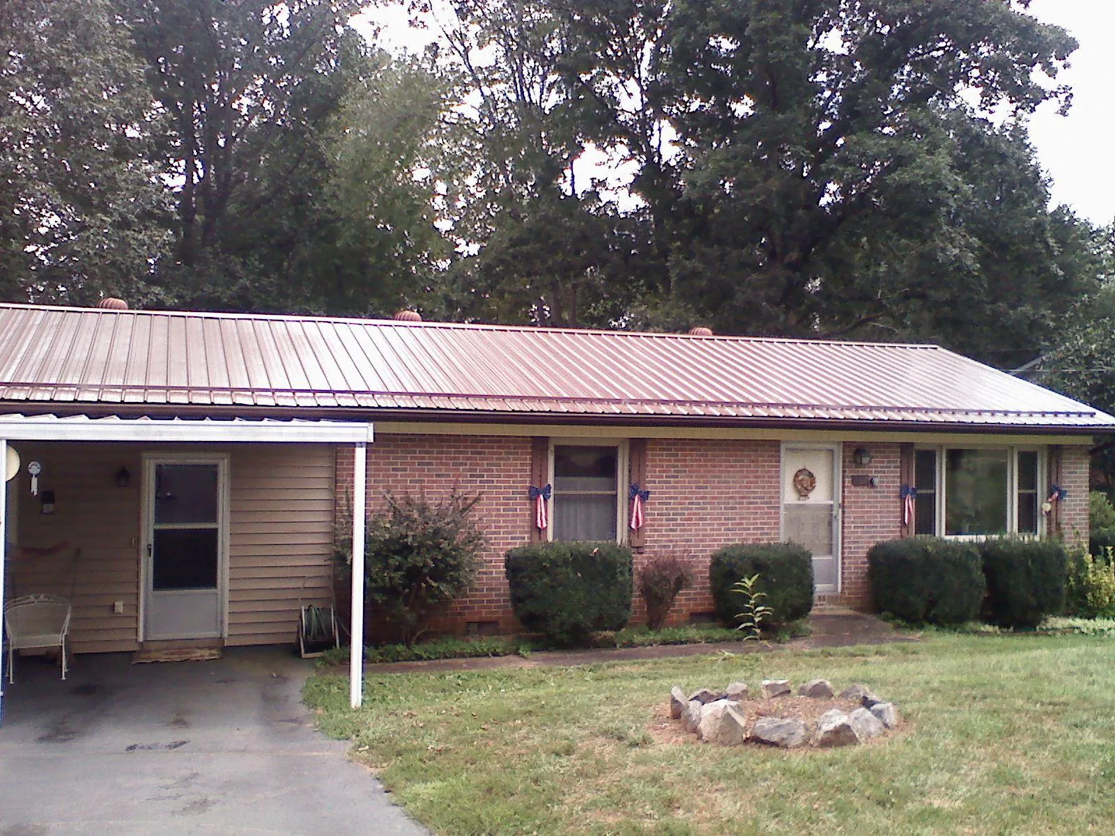 Bronze metal roof and carport on a brick ranch home — Roof Repair work by our crew in Holliston